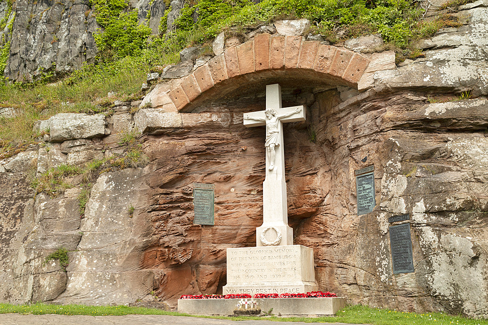 War Memorial, depicting Jesus Christ crucified, in memory of the Fallen of World War One and World War Two, in the village of Bamburgh, Northumberland, England, United Kingdom, Europe