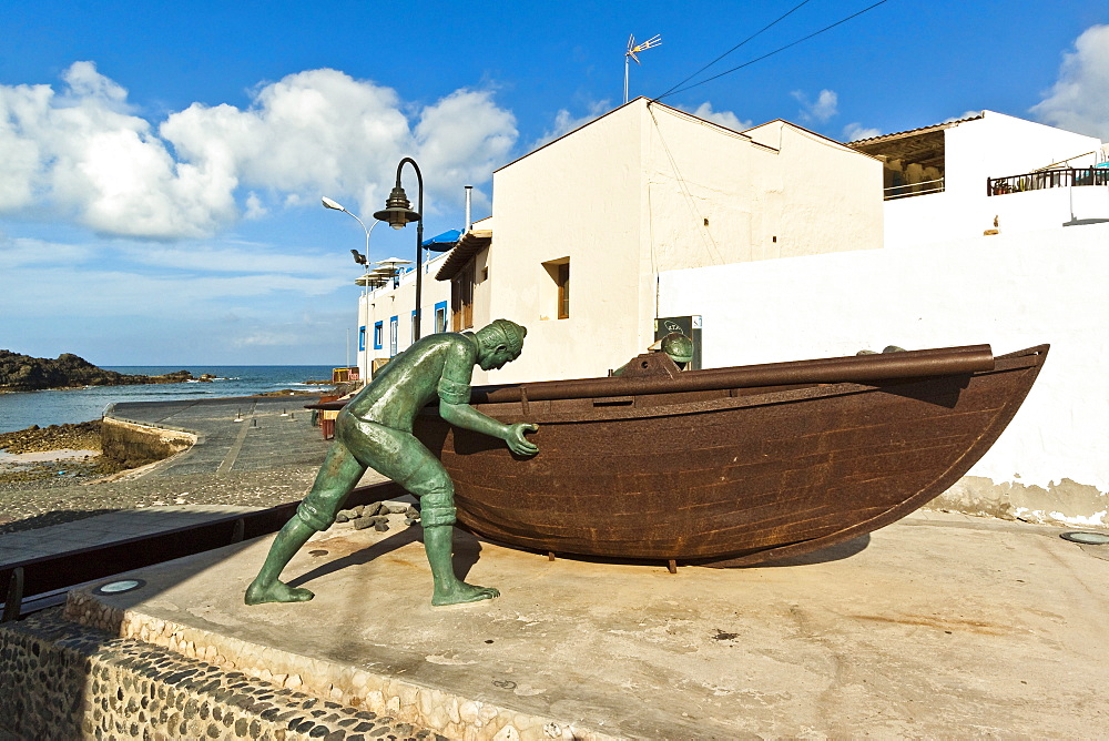 Boat with statues of fishermen at the old harbour in this north west coast village, El Cotillo, Fuerteventura, Canary Islands, Spain, Atlantic, Europe