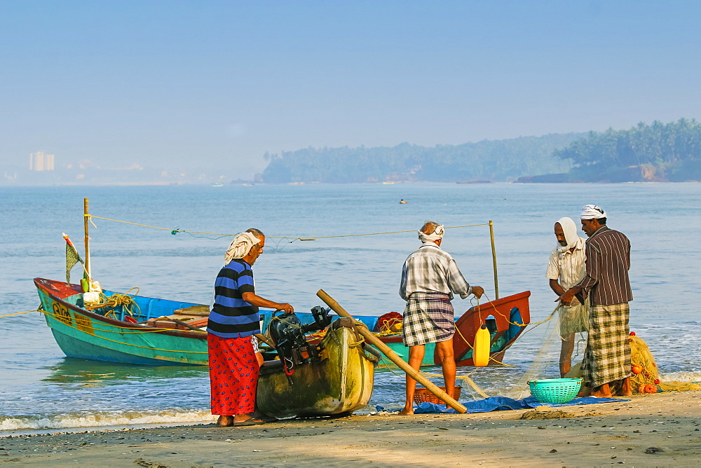 Fishermen cleaning net at beautiful Kizhunna Beach, south of Kannur on the Keralan north coast, Kizhunna, Kannur, Kerala, India, Asia