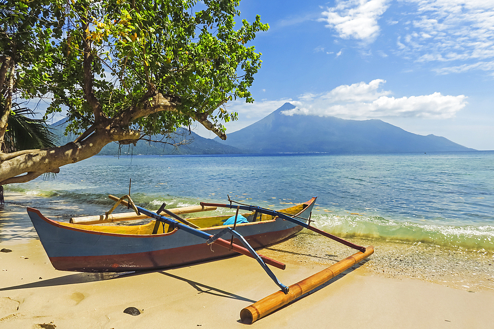 Outrigger canoe moored on Kalea Beach with active Karangetang volcano beyond, Kalea, Siau Island, Sangihe Archipelago, North Sulawesi, Indonesia, Southeast Asia, Asia