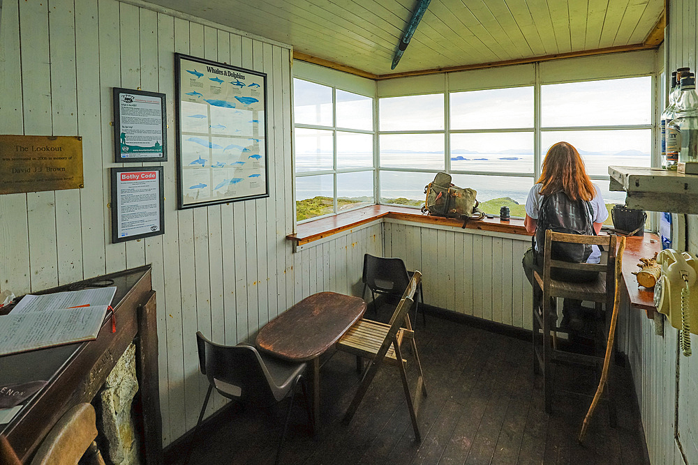 Woman hiker looks out from Rubha Hunish Coast Guard lookout bothy to the Shiant Isles and Harris at this northernmost tip of Skye, an SSSI  due to its geology and maritime cliffs, Rubha Hunish, Duntulm, Skye, Inner Hebrides, Scotland, United Kingdom, Europe