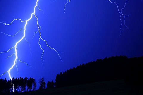 Thunderstorm, lightning striking a forest