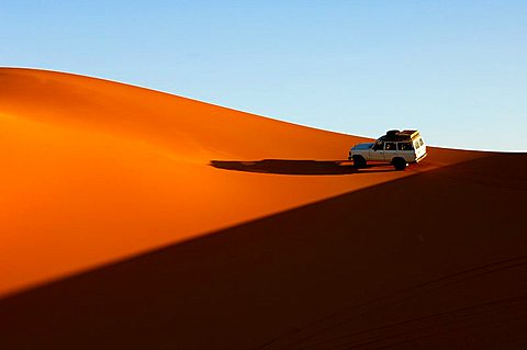 Jeep riding on sa and dune in the Sahara desert escaping the evening shadow Erg Ubari Idhan Awbari Libya