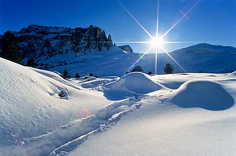 Twinkling sun and landscape deeply covered in snow, Sella Pass in winter, Bolzano-Bozen, Italy, Europe