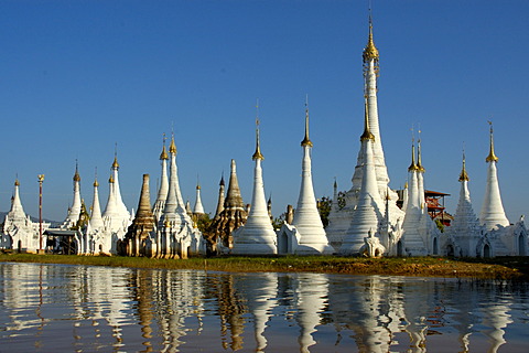 Slim stupas of Aung Min Ga Lar Paya reflect in the water Inle Lake Shan State Burma