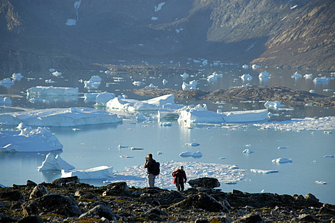 People in front of fjord with icebergs and mountains Nagtivit Kangertivat Fjord Eastgreenland