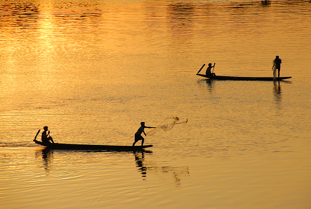 Sunset fishermen in boats throwing nets on the Mekong River Muang Khong Si Phan Don Laos