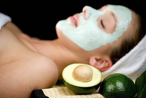 Young woman with a facial avocado mask