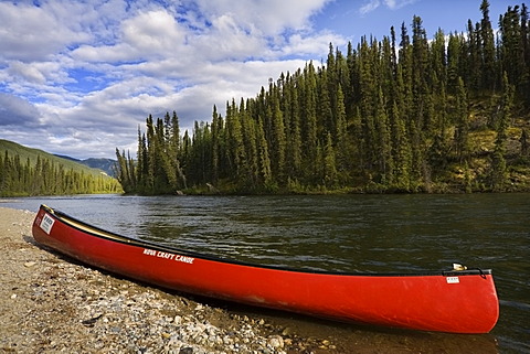 Red canoe on the shore of Big Salmon River, Yukon Territory, Canada, North America