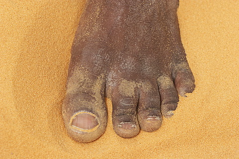 Foot and toes of a man in sand