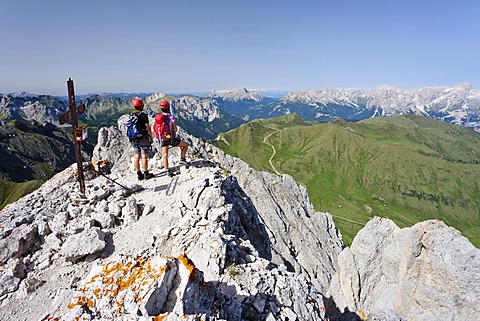 Climber on the summit of Colac on the Via Ferrata dei Finanzieri in Val di Fassa, Dolomites, behind the Rose Garden Group and the Latemar, Trentino Province, Italy, Europe