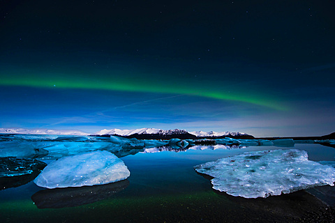 Chunks of ice in the water at the blue hour with polar lights, JÃ¶kulsÃ¡rlÃ³n lake, Vik, Iceland, Europe