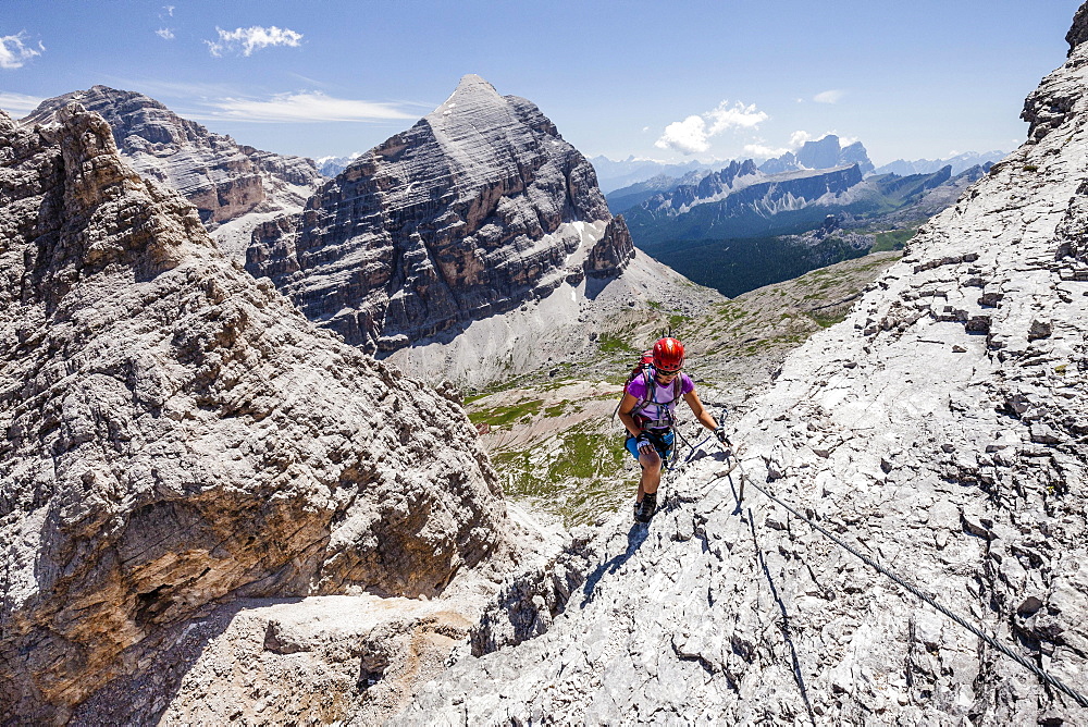 Mountaineer, Via Ferrata Tomaselli, southern Fanes peak, Tofana di Rozes, Tofana di Mezzo and Pelmo behind, Dolomites, Belluno, Alps, Italy, Europe