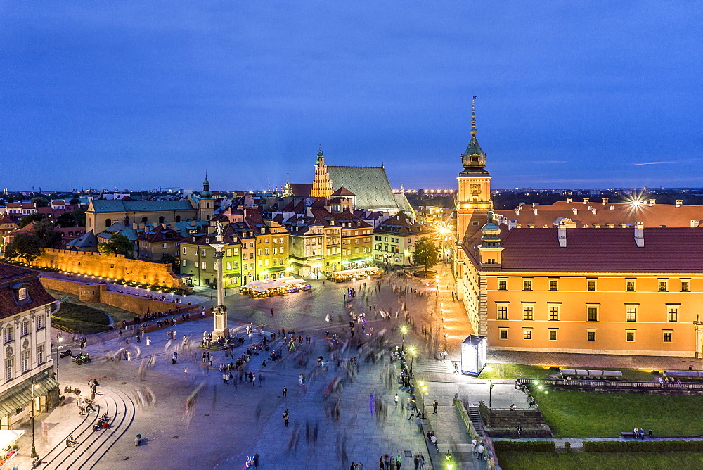 Royal Castle and Sigmund Column monument with many people passing by in the evening, Warsaw, Poland, Europe