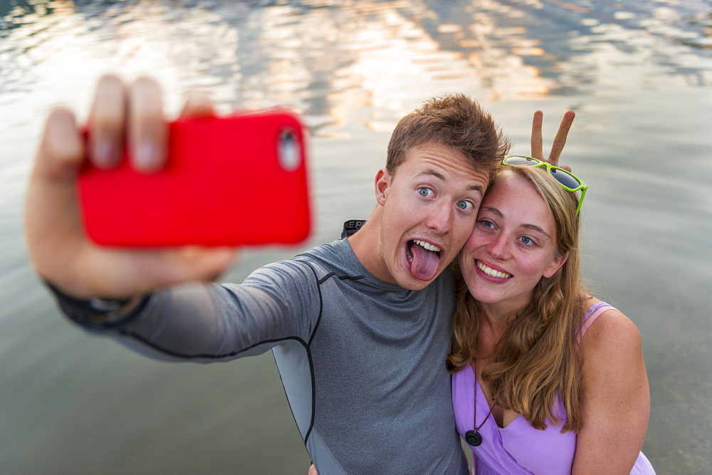 Young couple photographing themselves with mobile phone, selfie, Schliersee, Upper Bavaria, Bavaria, Germany, Europe