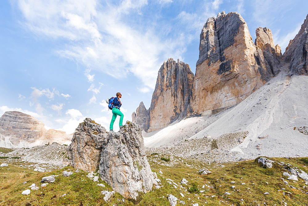 Hiker stands on rocks, north faces of the Three Peaks of Lavaredo, Sesto Dolomites, South Tyrol, Trentino-South Tyrol, Alto-Adige, Italy, Europe