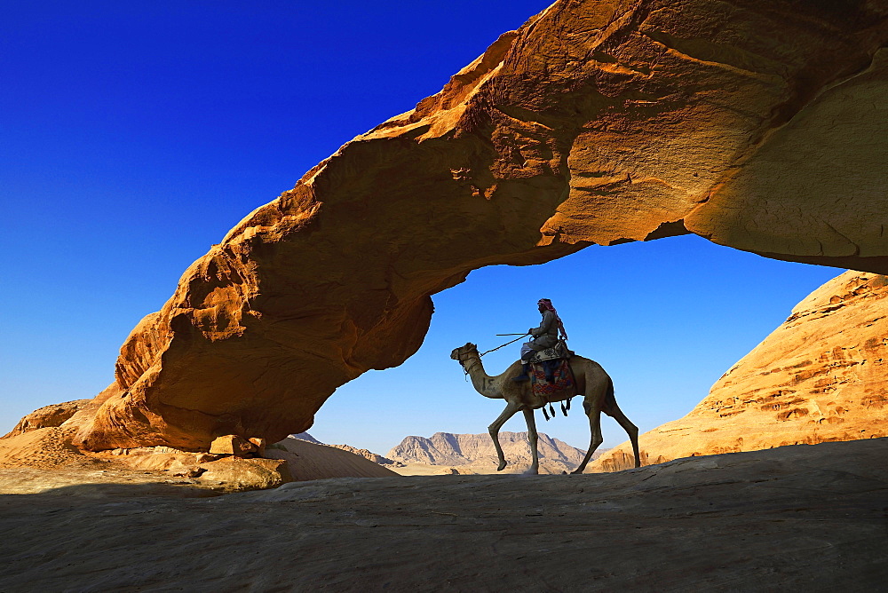 Bedouin rides his camel, Rock-Arch Al Kharza, Wadi Rum, Jordan, Asia