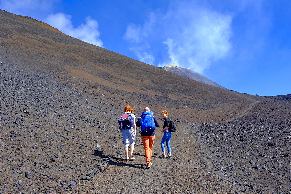 Hikers climbing through volcanic landscape, Volcano Etna, Province of Catania, Silzilia, Italy, Europe