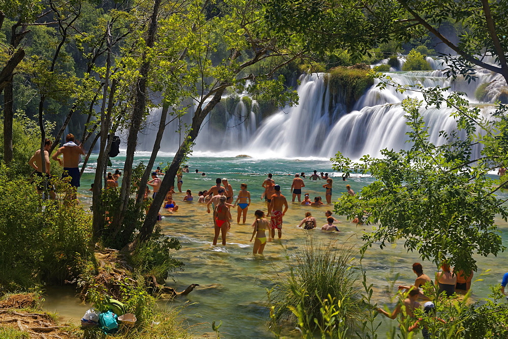 Tourists bathe at the waterfall Smotorcycleinski Buk, National Park Krka, Sibenik-Knin, Dalmatia, Croatia, Europe