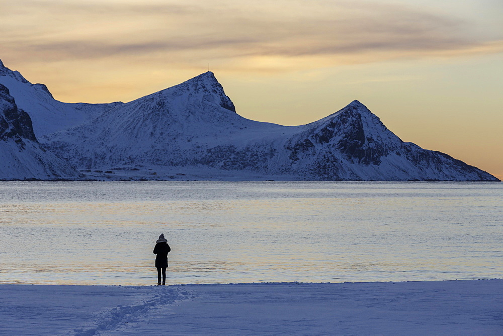 Stroller on snowy Haukland beach, Vestvagoy, Lofoten, Nordland, Norway, Europe