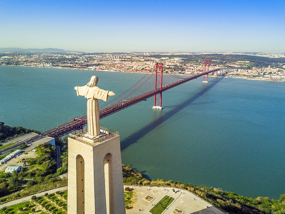 Jesus Christ monument by Tagus river with bridge Ponte 25 de Abril, Lisbon, Portugal, Europe