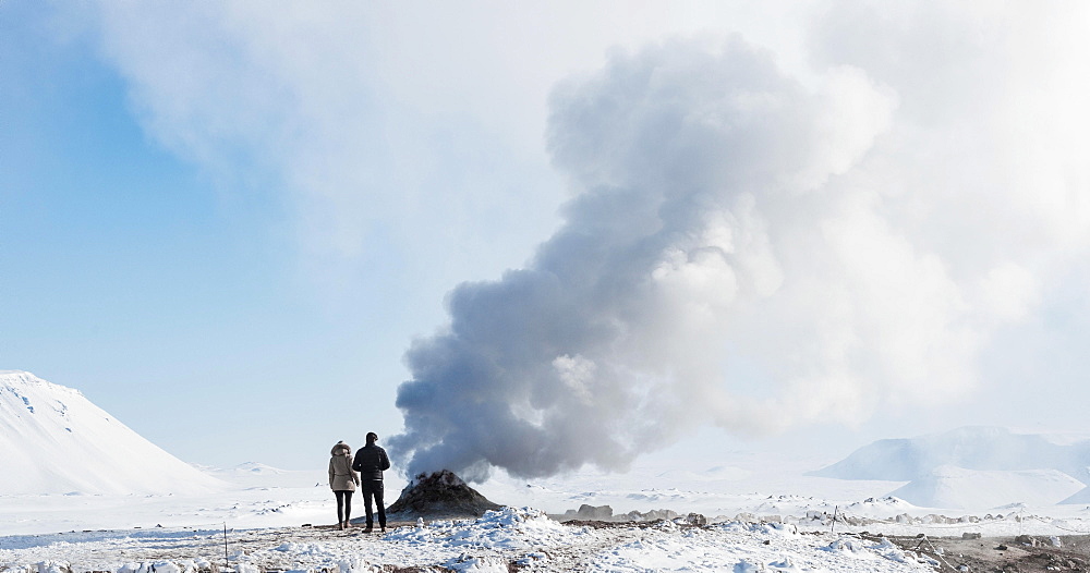 Two tourists standing beside steaming fumarole, solfatara in Hverarond, also Hverir or Namaskard, geothermal area, North Iceland, Iceland, Europe