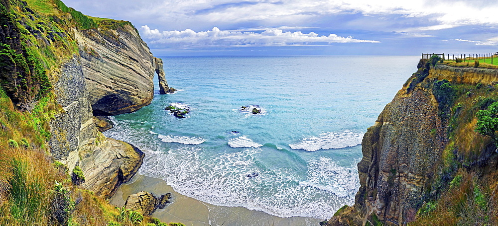 Steep cliff with arch of rock and small sandy beach, Cape Farewell, Tasman Sea, Puponga, North Island, New Zealand, Oceania