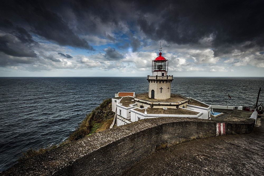 Lighthouse Farol da Ponta do Arnel at the sea, dark clouds, north-east, Sao Miguel, Azores, Portugal, Europe