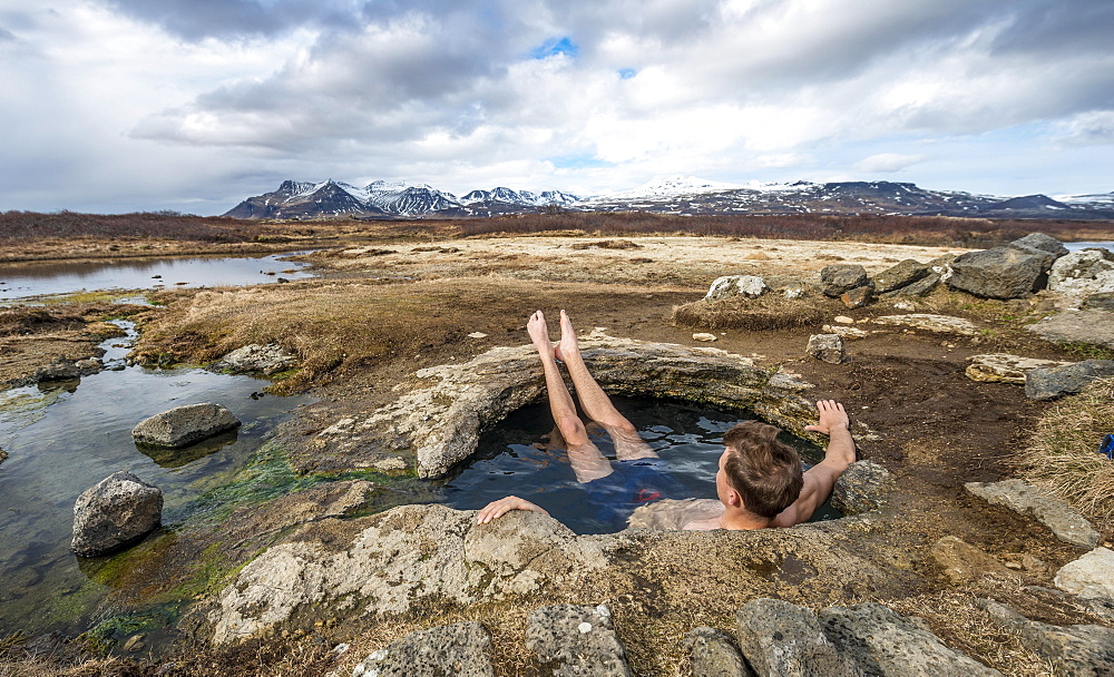 Young man in a hot spring, near Eyjar og Miklaholt, Vesturland, Iceland, Europe