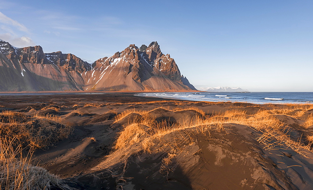 Evening atmosphere, Black sand beach, dunes with dry grass, mountains Klifatindur, Eystrahorn and Kambhorn, headland Stokksnes, massif Klifatindur, Austurland, East Iceland, Iceland, Europe