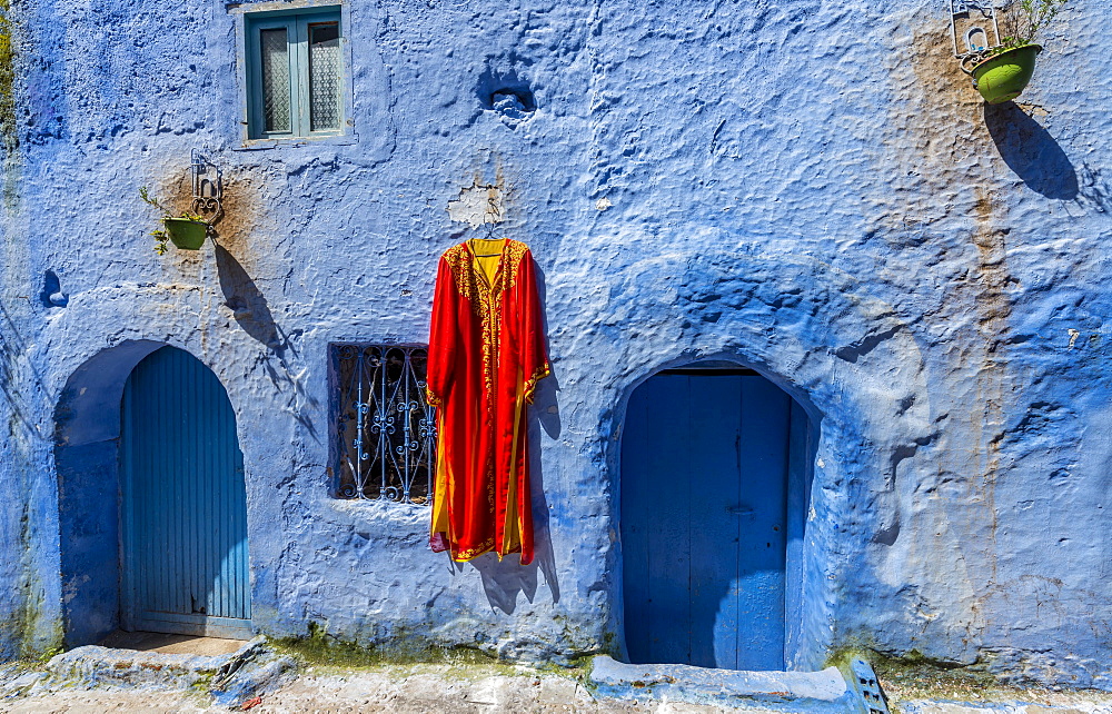 House facade, red dress hangs on blue painted house, medina of Chefchaouen, Chaouen, Tangier-Tétouan, Morocco, Africa