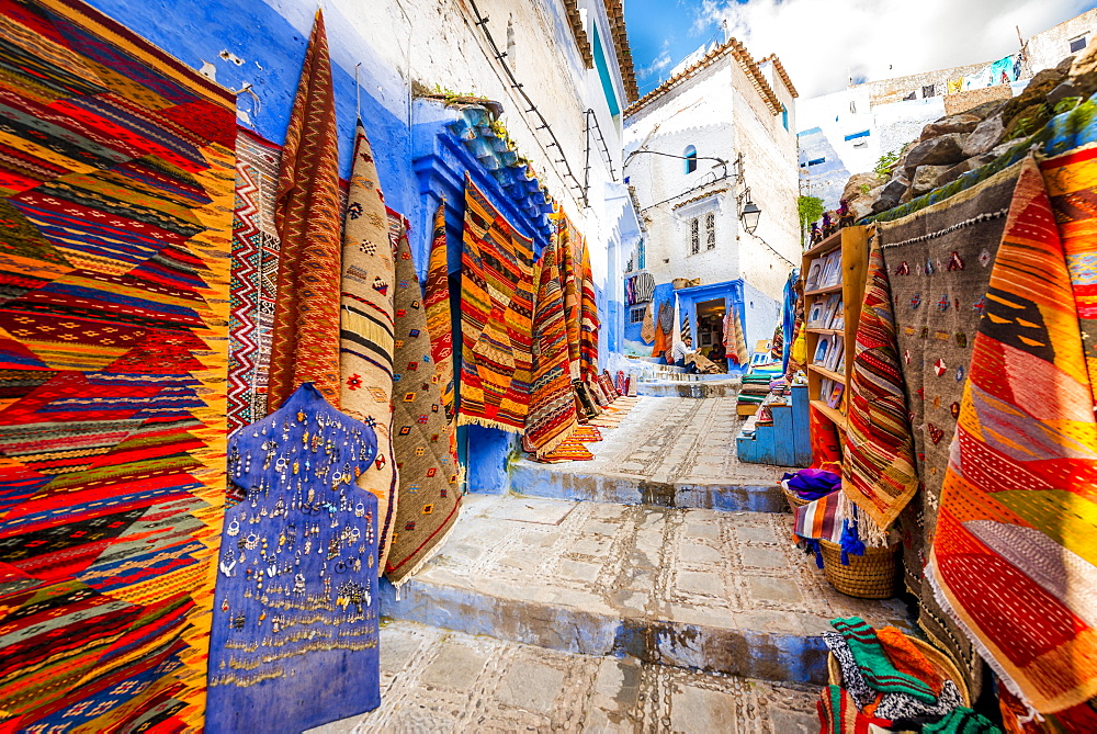 Narrow alley with carpets, carpet dealers, blue houses, medina of Chefchaouen, Chaouen, Tangier-Tétouan, Morocco, Africa