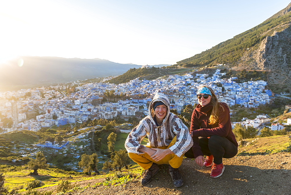 Young couple in Moroccan djellaba at lookout point, view on the medina of Chefchaouen, Chaouen, Tangier-Tétouan, Morocco, Africa