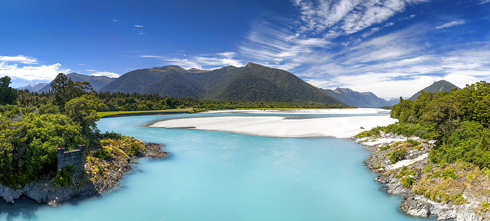 Türkiser Arawhata River, on the shore green forest, behind the summit of the Southern Alps, Mount Aspiring National Park, West Coast, South Island New Zealand