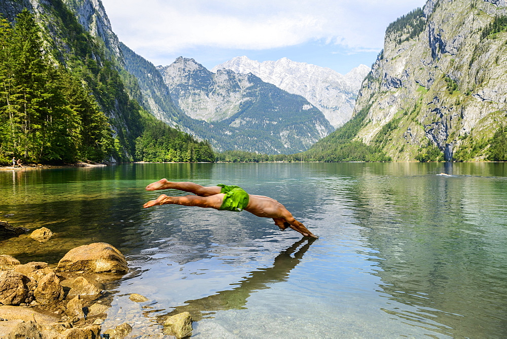 Young man jumps into Lake Obersee, swimming, mountain lake, mountain landscape, in the back Watzmann massif, Salet am Konigssee, Berchtesgaden National Park, Berchtesgadener Land, Upper Bavaria, Bavaria, Germany, Europe