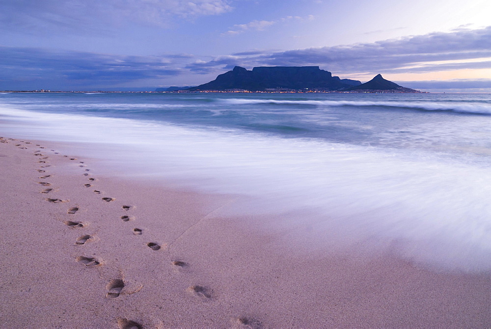 Table Mountain, Lion's Head and Devil's Peak in the evening light, panoramic view of Cape Town, footprints on Bloubergstrand beach, Table Bay in the Atlantic Ocean, Cape Town, Western Cape, South Africa, Africa