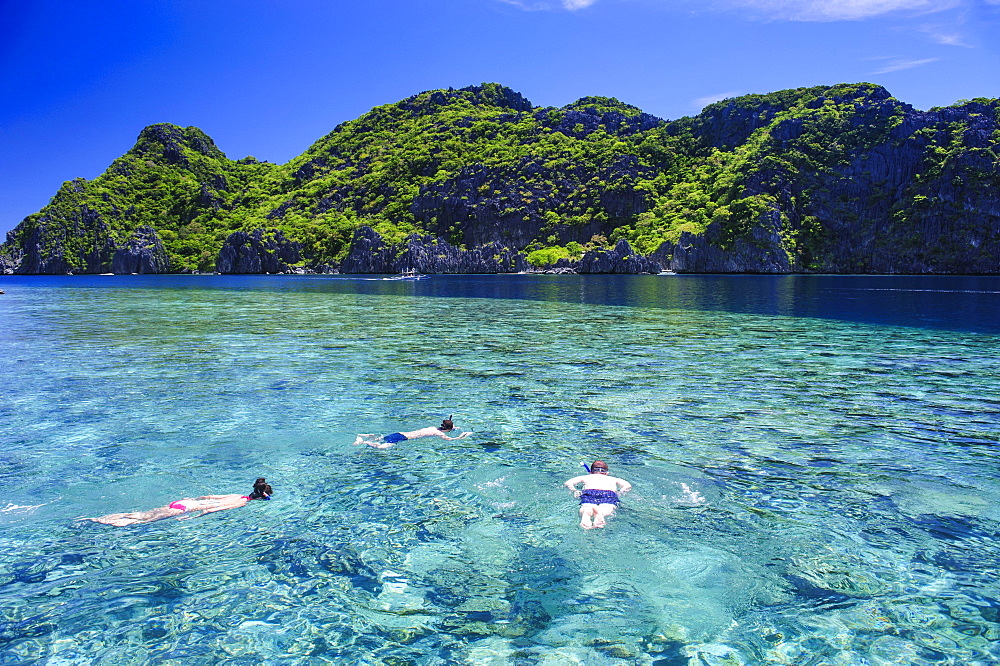 Tourists snorkeling in the crystal clear water in the Bacuit archipelago, Palawan, Philippines, Asia