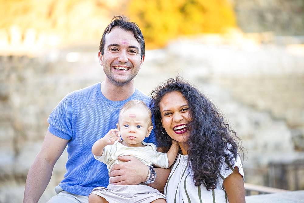 Young happy couple enjoying time with small baby boy, father and son with lipstick prints on their foreheads, Poland, Europe