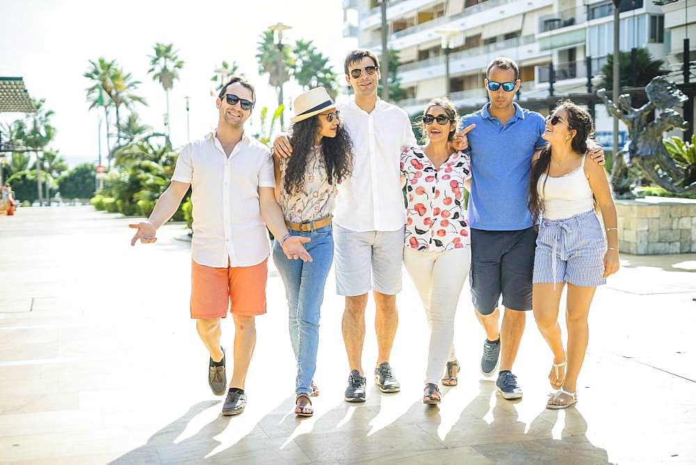 Six friends walking, taking, laughing and having fun during day time in urban setting, Portugal, Europe