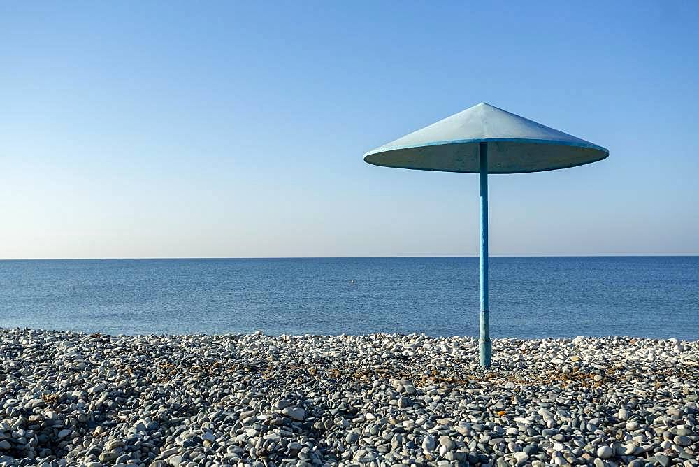 Blue umbrella on the pebble beach, Cyprus, Europe