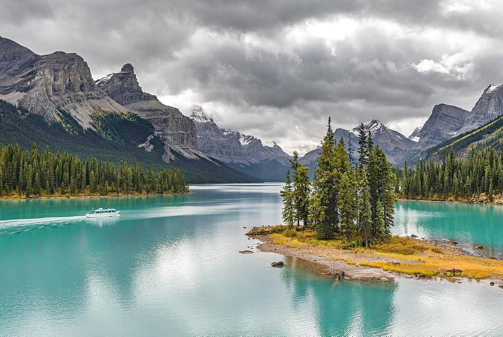 Island in a lake, Spirit Island in the glacier lake Maligne Lake, with excursion boat, back mountains Mount Paul, Monkhead and Mount Warren, Maligne Valley, Jasper National Park National Park, Canadian Rocky Mountains, Alberta, Canada, North America