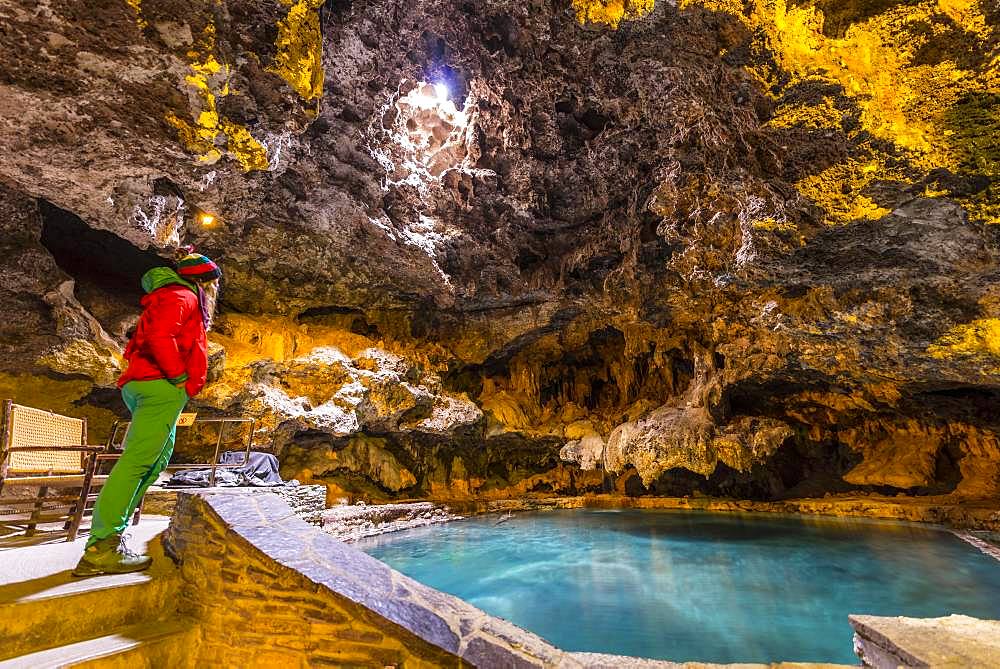 Young woman in a cave with a geothermal spring, Cave and Basin National Historic Site, Banff National Park, Alberta, Canada, North America