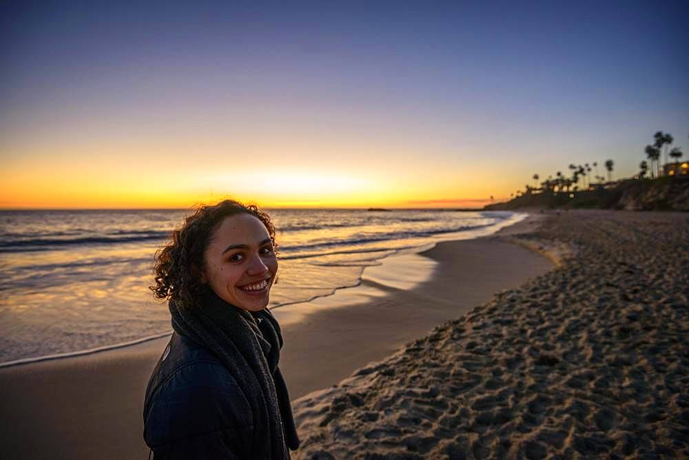 Young woman on the beach at sunset, Laguna Beach, Orange County, California, USA, North America