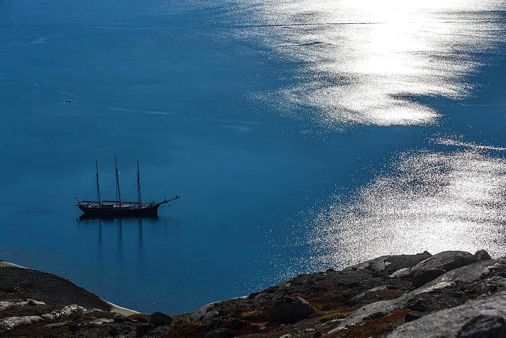 Sailing ship and light reflections on the water surface, Scoresbysund, East Greenland, Greenland, North America