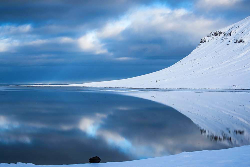 Snow-covered coastal landscape with water reflection, north coast of the peninsula Snaefellsnes, Grundarfjoerdur, Iceland, Europe