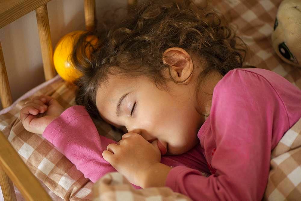 Girl, 3 years, portrait, sleeps in bed, with thumb in mouth, Germany, Europe