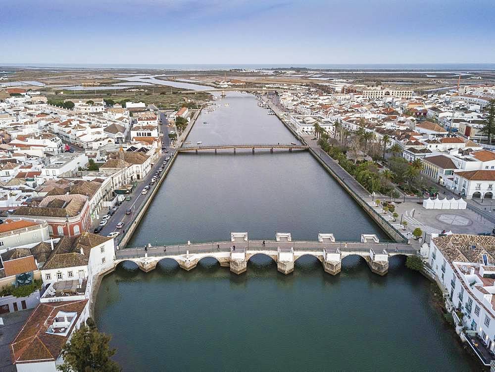 City view with roman bridge over Gilao river in old fishermen's town, Tavira, drone shot, Algarve, Portugal, Europe