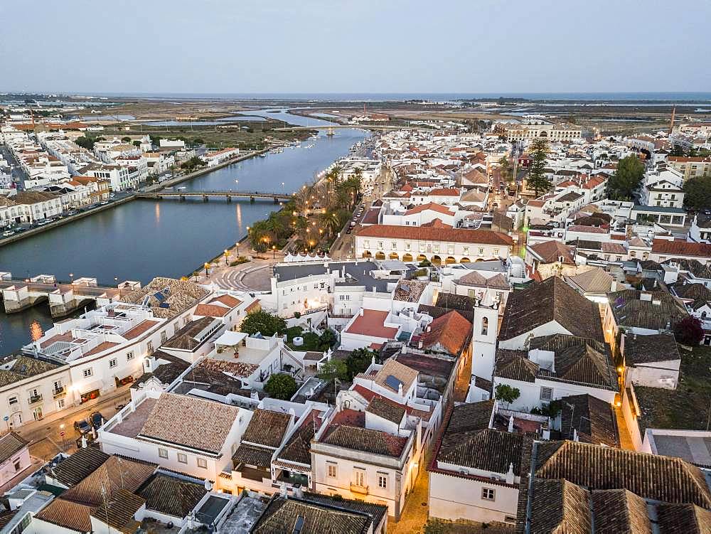 City view with roman bridge over Gilao river in old fishermen's town in the evening light, Tavira, drone shot, Algarve, Portugal, Europe