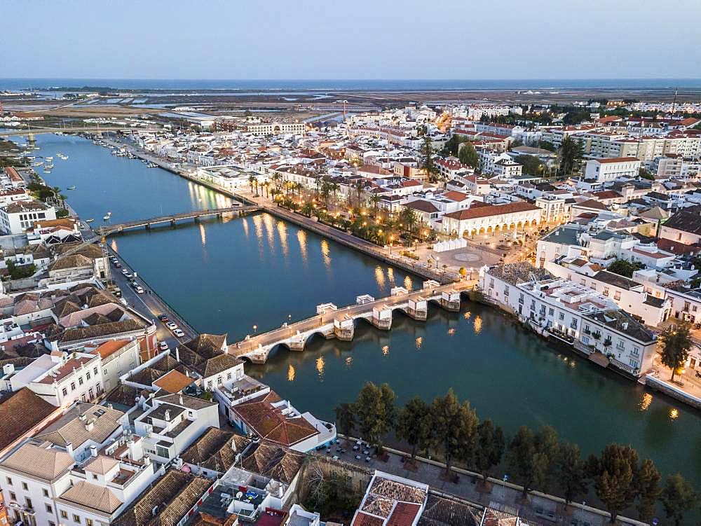 City view with roman bridge over Gilao river in old fishermen's town in the evening light, Tavira, drone shot, Algarve, Portugal, Europe