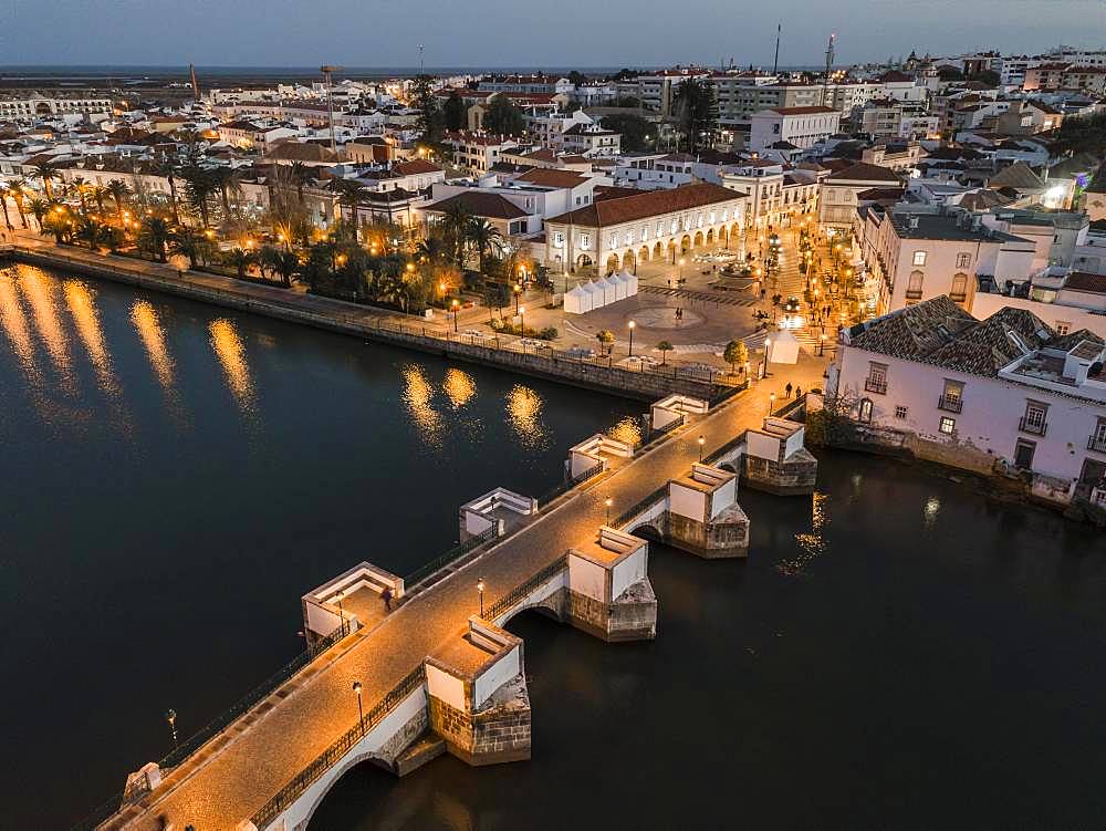 City view with roman bridge over Gilao river in old fishermen's town in the evening light, Tavira, drone shot, Algarve, Portugal, Europe